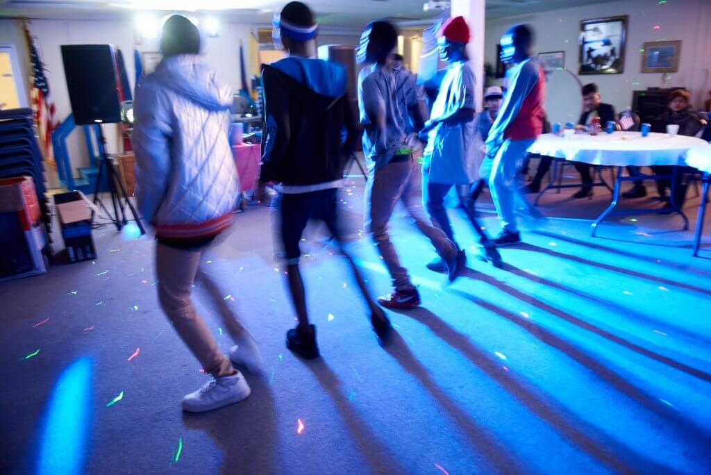 Five teenagers dancing at an event