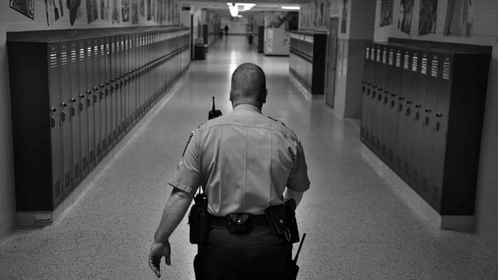 A police officer in a school hallway