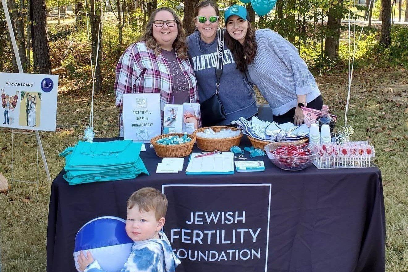 Volunteers pose at a booth promoting the Jewish Fertility Foundation
