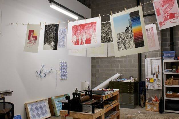 Prints hang to dry in a printmaking studio