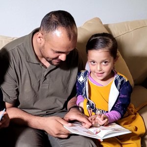 Photo of a father and his daughter, newly arrived Afghan evacuees living in Colorado.