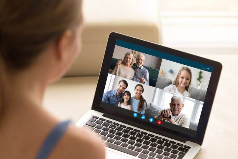 A woman on a video call with multiple members of her family